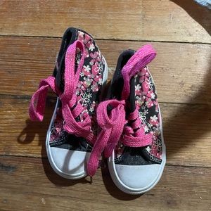 Tennis shoes with hot pink strings and flowers on them